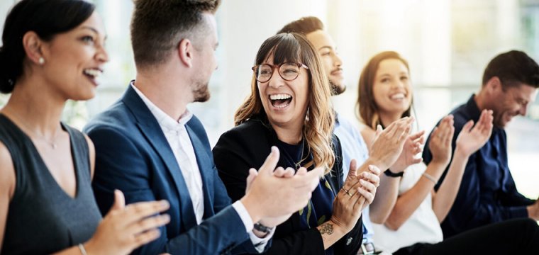 Group of people at an event laughing and clapping