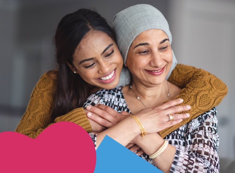 A woman hugging a Keech Hospice patient from behind while the Keech heart and a square is collaged in the bottom left corner
